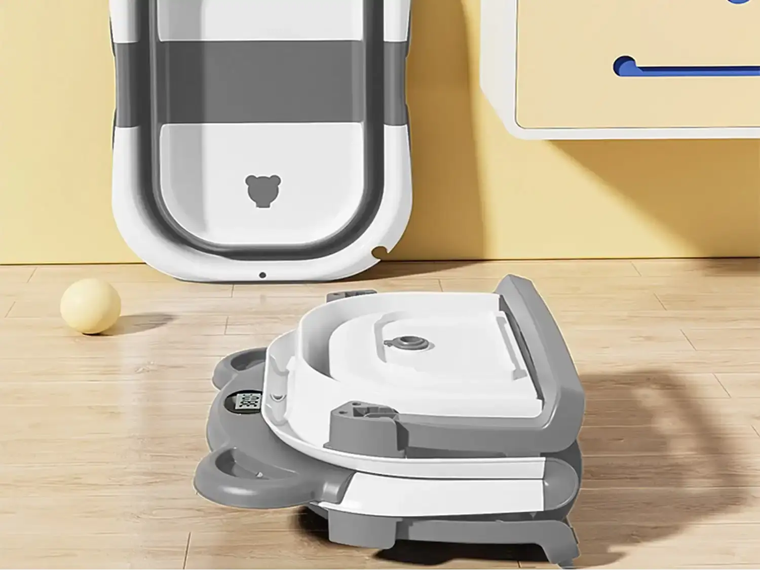 Baignoire pliable bébé éco avec thermomètre intégrée, design compact gris et blanc, idéale pour un bain sécurisé et confortable à la maison.