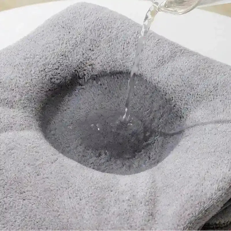 Tissu absorbant gris montrant un écoulement d'eau absorbée au centre sur fond blanc